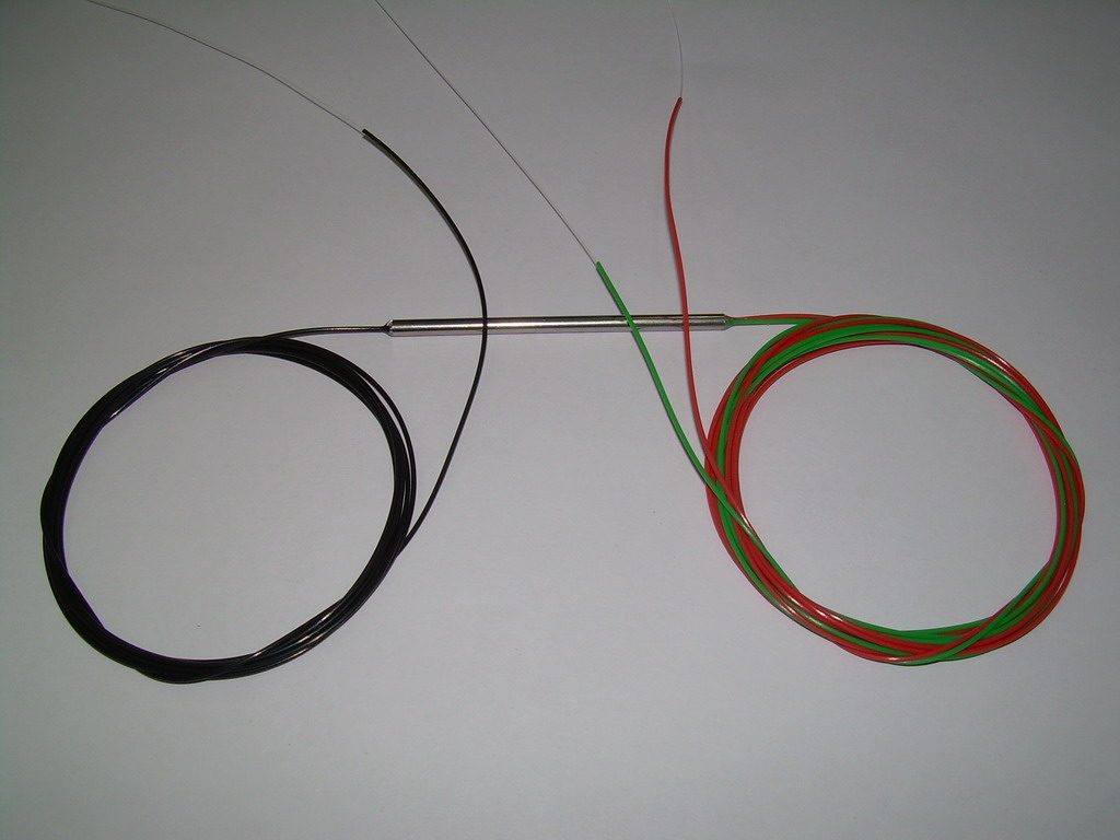 Optik bir WDM birleştiricisi: küçük pasif gövdeden çıkan ince fiber kuyrukçuklar, ayrı dalga boylarındaki ışıkları tek bir lifte topluyor. Metnin çoğullayıcı ve çoklama çözücü dediği parçanın avuç içine sığan gerçek hâli.