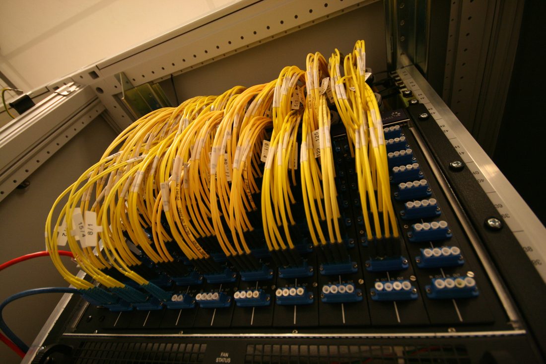 AMS-IX internet değişim noktasının optik bağlantı paneli: numaralandırılmış yuvalara takılı çok sayıda renkli fiber kordon. Ayrı otonom sistemlerin birbirine doğrudan hattı fiziksel olarak burada, tek bir panelde kuruluyor.